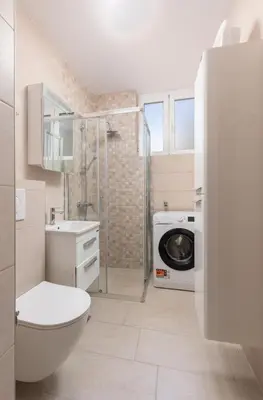 a bathroom with a toilet sink and a washing machine at Petrovic Family - Two Bedroom Apartment in Kotor