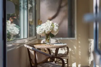 a small table with a vase of flowers on it at Petrovic Family - Two Bedroom Apartment in Kotor