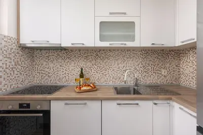a kitchen with white cabinets and a sink at Petrovic Family - Two Bedroom Apartment in Kotor