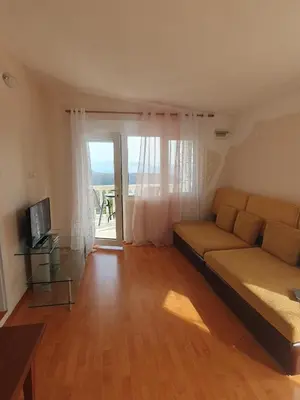 a living room with a couch and a sliding glass door at Traumhafte Wohnung mit Meerblick in Sutomore in Sutomore