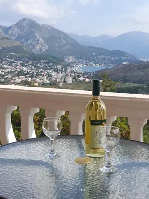 a bottle of wine sitting on a table with two wine glasses at Traumhafte Wohnung mit Meerblick in Sutomore in Sutomore