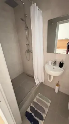 a white bathroom with a shower and a sink at GreenHouse in Bar