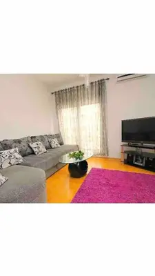 a living room with a couch and a television at Izvor in Budva