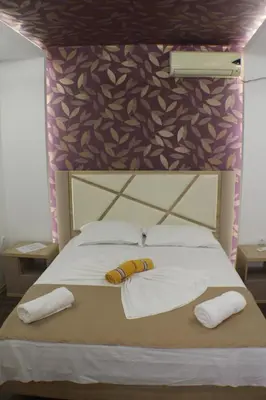 a bed with two pillows and two towels on it at Casa Hena in Ulcinj