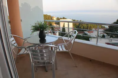 a table with chairs and a vase on a balcony at Casa Hena in Ulcinj