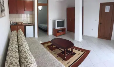 a living room with a couch and a table and a television at Casa Hena in Ulcinj