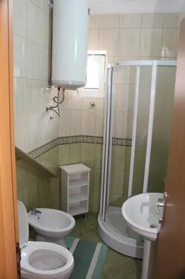 a bathroom with a shower and a toilet and a sink at Casa Hena in Ulcinj