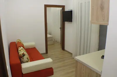 a living room with a red couch in a room at Casa Hena in Ulcinj