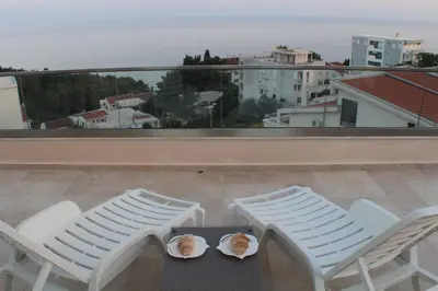 two white chairs and a table on a balcony at Casa Hena in Ulcinj