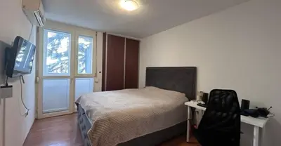 a bedroom with a bed and a desk and a television at Stan na dan in Bar