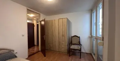a bedroom with a bed and a chair next to a door at Stan na dan in Bar
