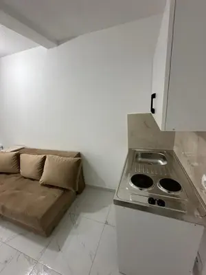 a small kitchen with a stove and a couch at Dilan apartments by the sea in Bar