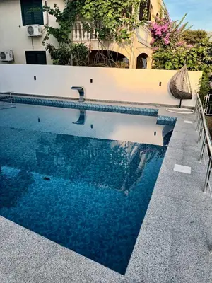 a swimming pool with blue water in front of a building at Dilan apartments by the sea in Bar