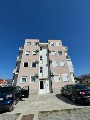 a tall building with two cars parked in front of it at Podgorica apartment - up to 4 persons in Podgorica
