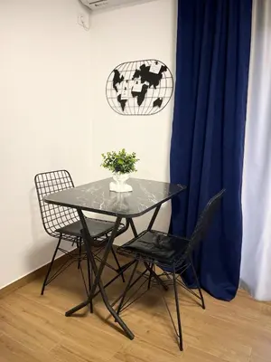 a table with two chairs and a vase of flowers on it at Luxury Lana apartments in Bar