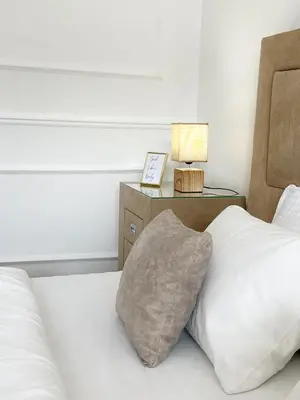 a bed with a pillow and a nightstand with a lamp at Luxury Lana apartments in Bar