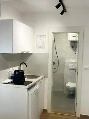 a white kitchen with a sink and a toilet at Luxury Lana apartments in Bar