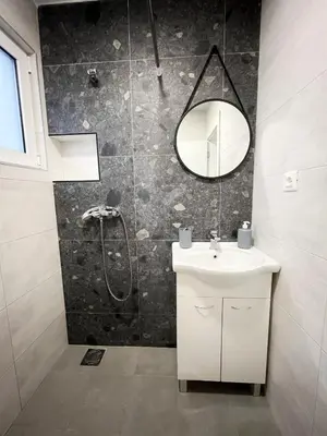 a bathroom with a shower and a sink and a mirror at Luxury Lana apartments in Bar