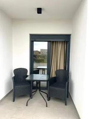 a table and two chairs in a room with a window at Luxury Lana apartments in Bar