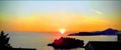a sunset over a body of water with the sun setting at Sunview Sveti Stefan in Sveti Stefan