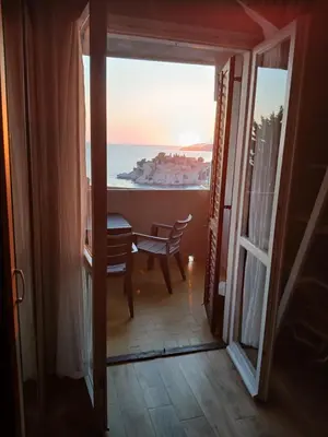 a room with a table and a view of the ocean at Sunview Sveti Stefan in Sveti Stefan