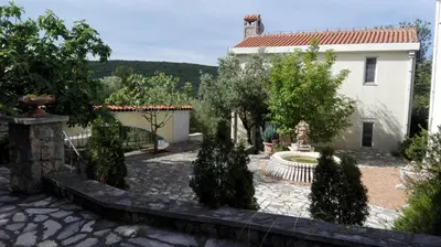 a garden in front of a house with a fountain at Suntime Villa 7 in Tivat