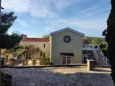 a building with a clock on the side of it at Suntime Villa 7 in Tivat