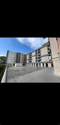 a large building with a parking lot in front of it at Apartment MJ in Budva