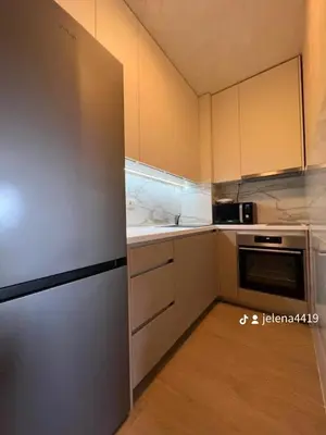 a kitchen with white cabinets and a stainless steel refrigerator at Apartment MJ in Budva