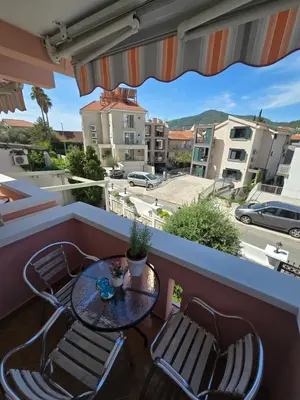 a table and chairs on a balcony with a view of a city at Garni Hotel Koral in Budva