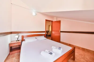 a bedroom with a bed with two towels on it at Garni Hotel Koral in Budva