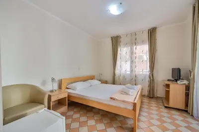 a bedroom with a bed and a couch and a television at Garni Hotel Koral in Budva