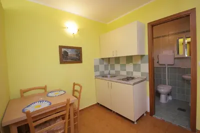 a kitchen with a table and a sink and a toilet at Apartments Tamara in Budva