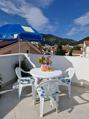 a table and two chairs and an umbrella on a balcony at Apartments Tamara in Budva