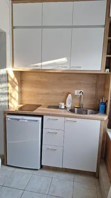 a kitchen with white cabinets and a sink at Studio Apartman Kamenovo in Pržno