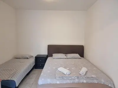 a bedroom with two beds with towels on them at Studio Apartman Kamenovo in Pržno