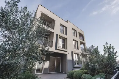 a white building with windows and trees at Moon apartment 2 in Podgorica