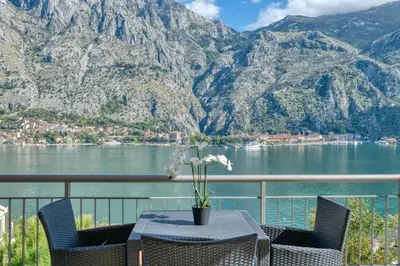 a table and chairs with a view of the mountains at Kotor Vista Seaview apartment by MN Property in Muo