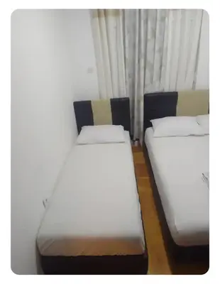 two beds sitting next to a window in a room at Stan Budva Rozino in Budva