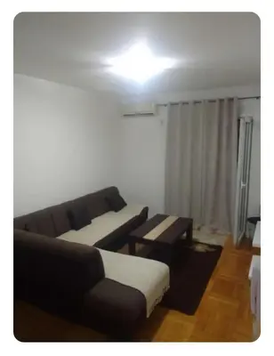 a living room with a couch and a table at Stan Budva Rozino in Budva