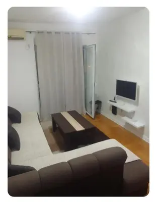 a living room with a couch and a tv at Stan Budva Rozino in Budva