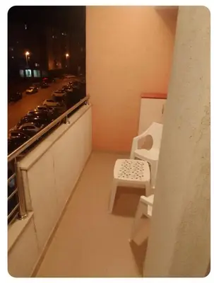 a balcony with a chair and a view of a street at Stan Budva Rozino in Budva