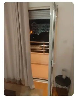 a door to a room with a window and a stool at Stan Budva Rozino in Budva