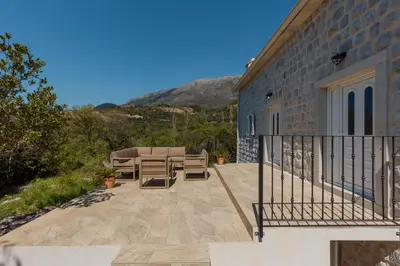 a patio with a table and chairs on a building at Villa Magic Stone in Šišići