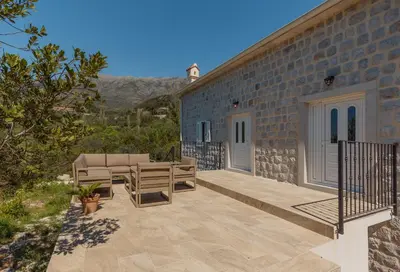 a patio with chairs and a brick building at Villa Magic Stone in Šišići