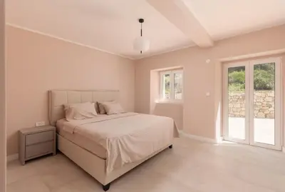 a white bedroom with a bed and a window at Villa Magic Stone in Šišići