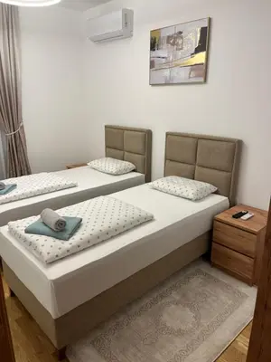 two beds sitting next to each other in a room at Emel Apartman in Ulcinj