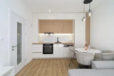 a kitchen with white cabinets and a table in a room at Montenegrina apartment in Cetinje