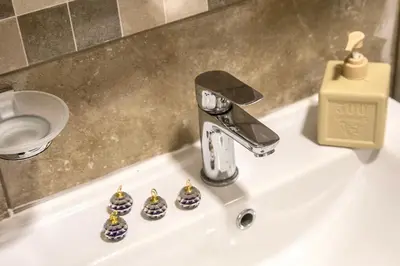 a bathroom sink with a faucet and four balls at Montenegrina apartment in Cetinje