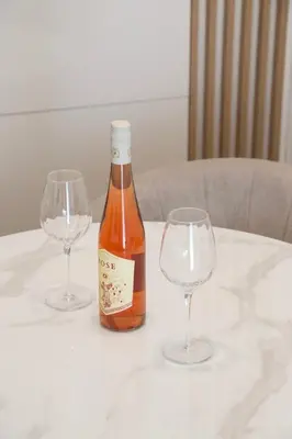 a bottle of wine and two wine glasses on a table at Montenegrina apartment in Cetinje